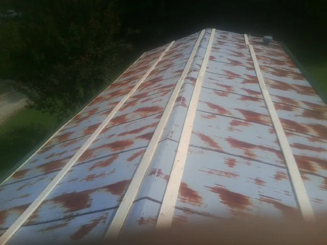 Rusted metal roof panels with new wood purlins before replacement — Storm Damage Roof Repair in Caret by Roofing Brothers