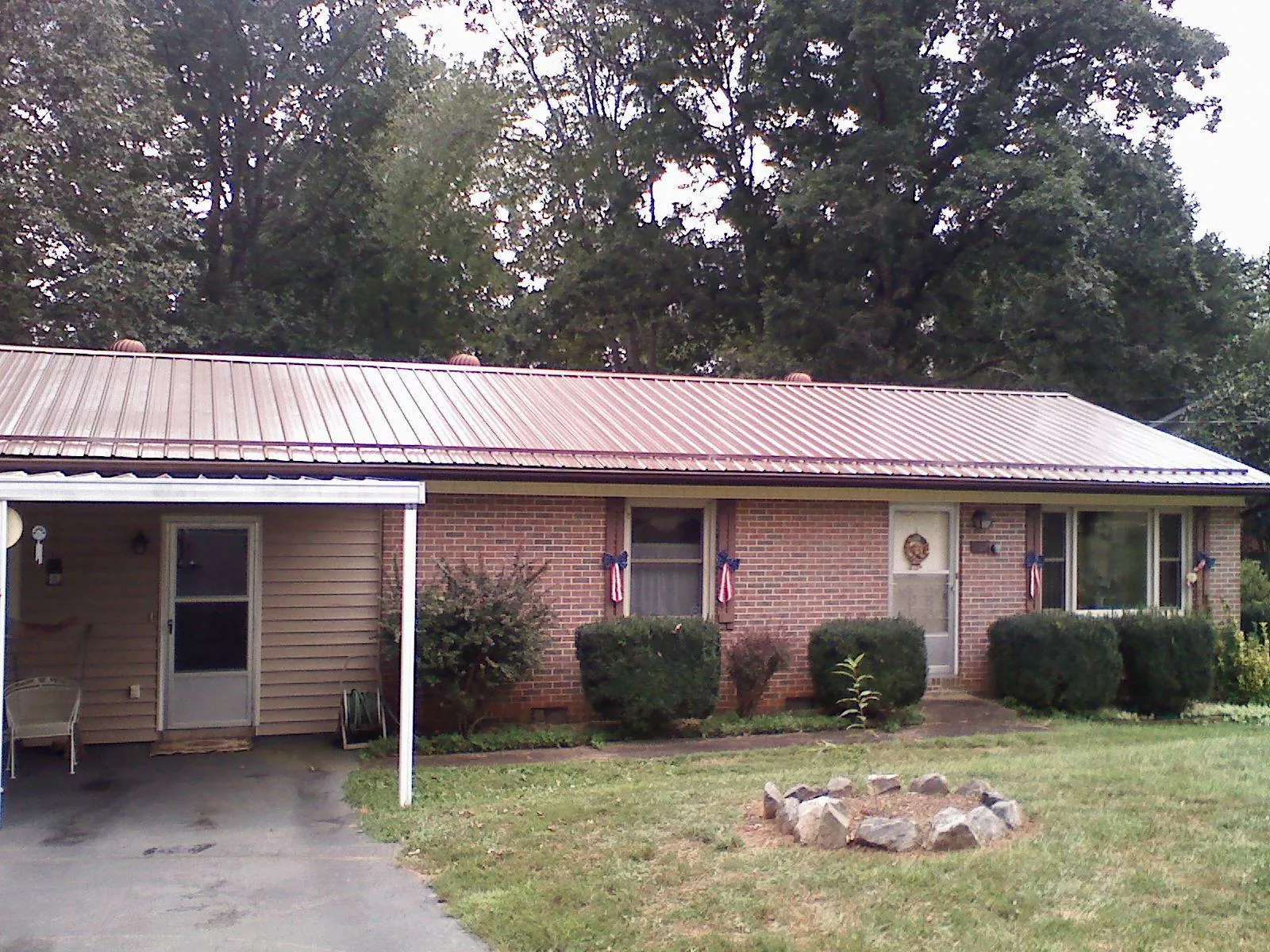 Bronze metal roof and carport on a brick ranch home — Roof Repair work by our crew in Caret